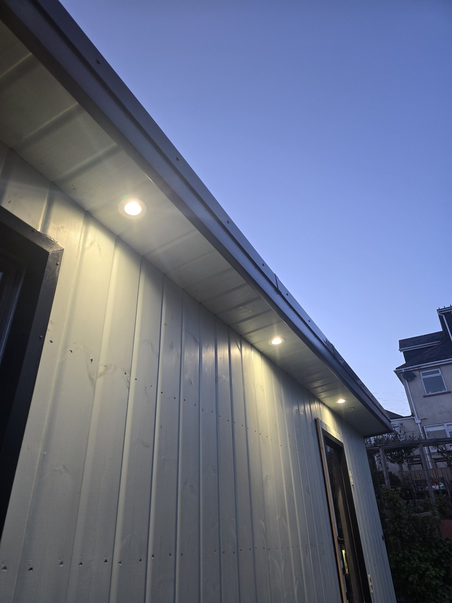 Exterior soffit lights illuminating a home at dusk